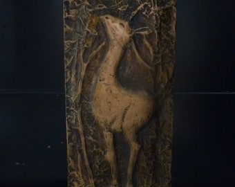 May include: A copper wall sculpture of a deer with a textured background.