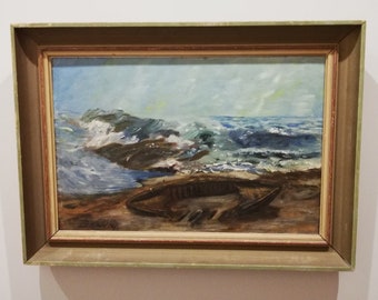 Op de afbeelding: Een ingelijst olieverfschilderij dat een zeezicht voorstelt met brekende golven en een houten boot die op een zandstrand is aangespoeld.