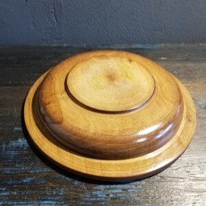 May include: A wooden serving tray with a natural finish. The tray has a raised edge and a smooth surface.