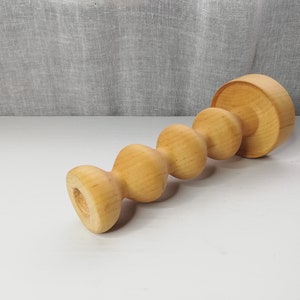 Puede incluir: Un portavelas de madera con un dise&ntilde;o &uacute;nico y retorcido. El portavelas est&aacute; hecho de madera marr&oacute;n claro y tiene un acabado liso y pulido.