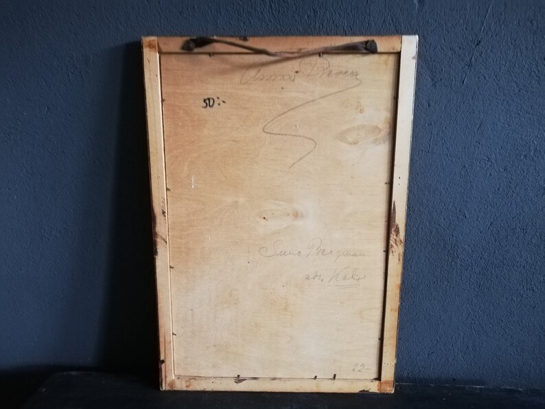 May include: The back of a framed artwork with a wooden frame. The back of the frame is made of wood and has a handwritten inscription that reads "Anna Brown, Sue the gunman, with love, Kathy".