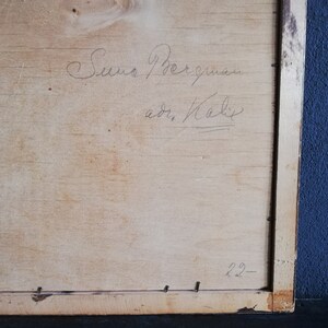 May include: A close-up of a wooden frame with a handwritten inscription that reads "Suno Bergman, adr. Kalix" and the number "22" written in the bottom right corner.
