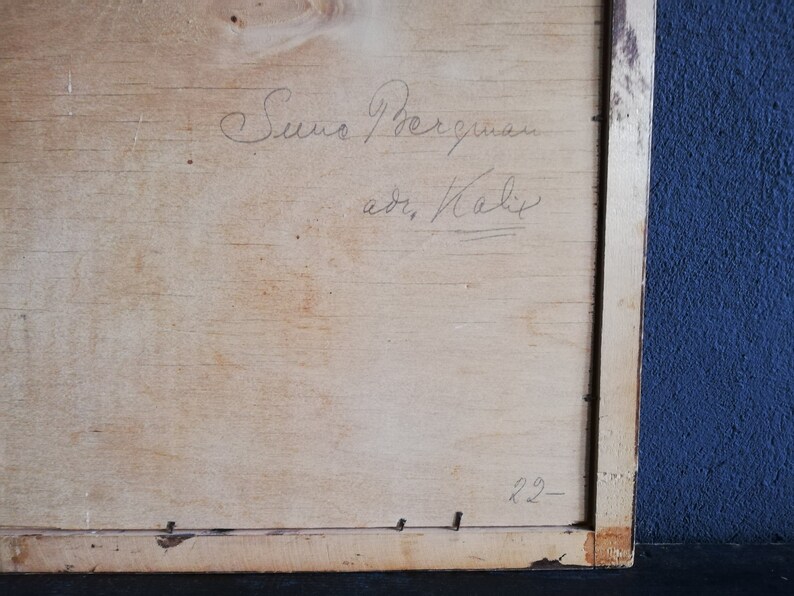 May include: A close-up of a wooden frame with a handwritten inscription that reads "Suno Bergman, adr. Kalix" and the number "22" written in the bottom right corner.