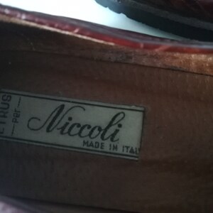 Puede incluir: Primer plano del interior de un zapato de cuero marr&oacute;n con una etiqueta blanca que dice "Etrus - per - Niccoli MADE IN ITALY".