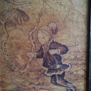 May include: A woodburned image of a child wearing a hat and coat, ice skating on a frozen lake. The child is holding a rope attached to a tree branch. The background is a woodgrain pattern.
