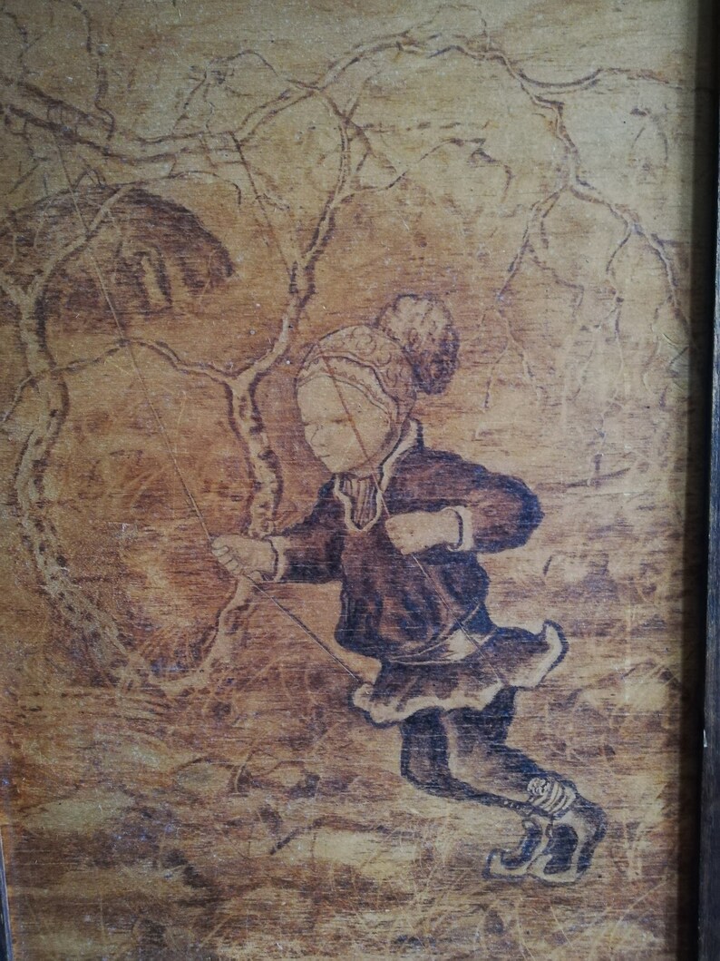 May include: A woodburned image of a child wearing a hat and coat, ice skating on a frozen lake. The child is holding a rope attached to a tree branch. The background is a woodgrain pattern.