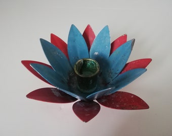 May include: A blue and red metal lotus flower candle holder with a green glass candle holder in the center.