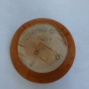 May include: A wooden bowl with a brown stain. The bottom of the bowl has the text "RSJ 1469 OLDER" written in blue ink.