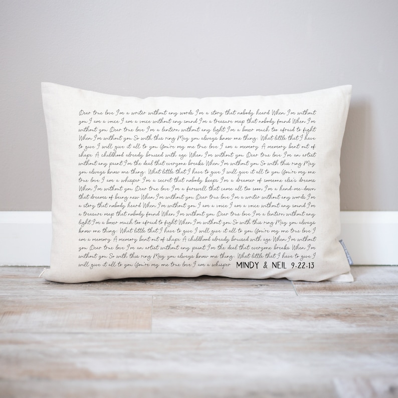 May include: A white pillow with black text that reads a love letter. The text says "Dear true love, I'm a writer without any words... I'm a whisper. MINDY & NEIL 9.22.13".