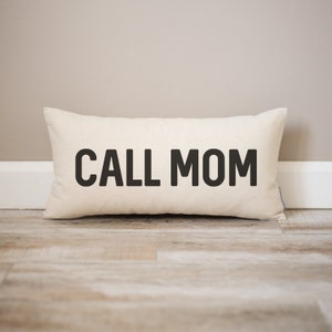 May include: A white rectangular pillow with black text that reads "CALL MOM".