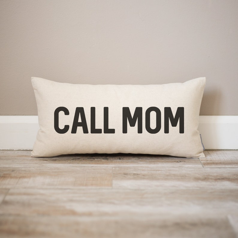May include: A white rectangular pillow with black text that reads "CALL MOM".