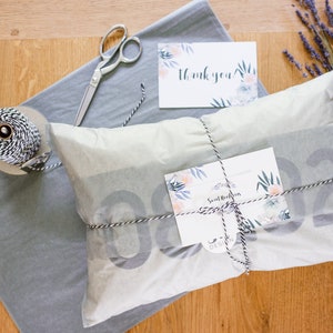 May include: A gift wrapped in white tissue paper with black and white twine. The gift is tied with a bow and has a small card attached to it that says "Sweet Nothings Design".