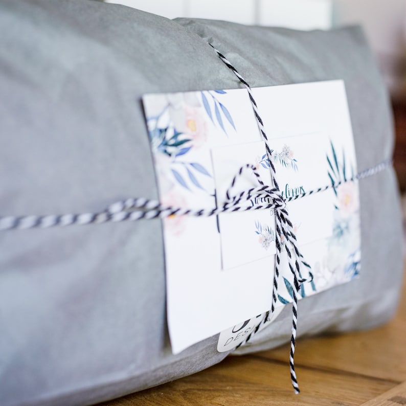 May include: A gray gift bag tied with black and white twine and a floral gift tag that says "Sweet Dreams".