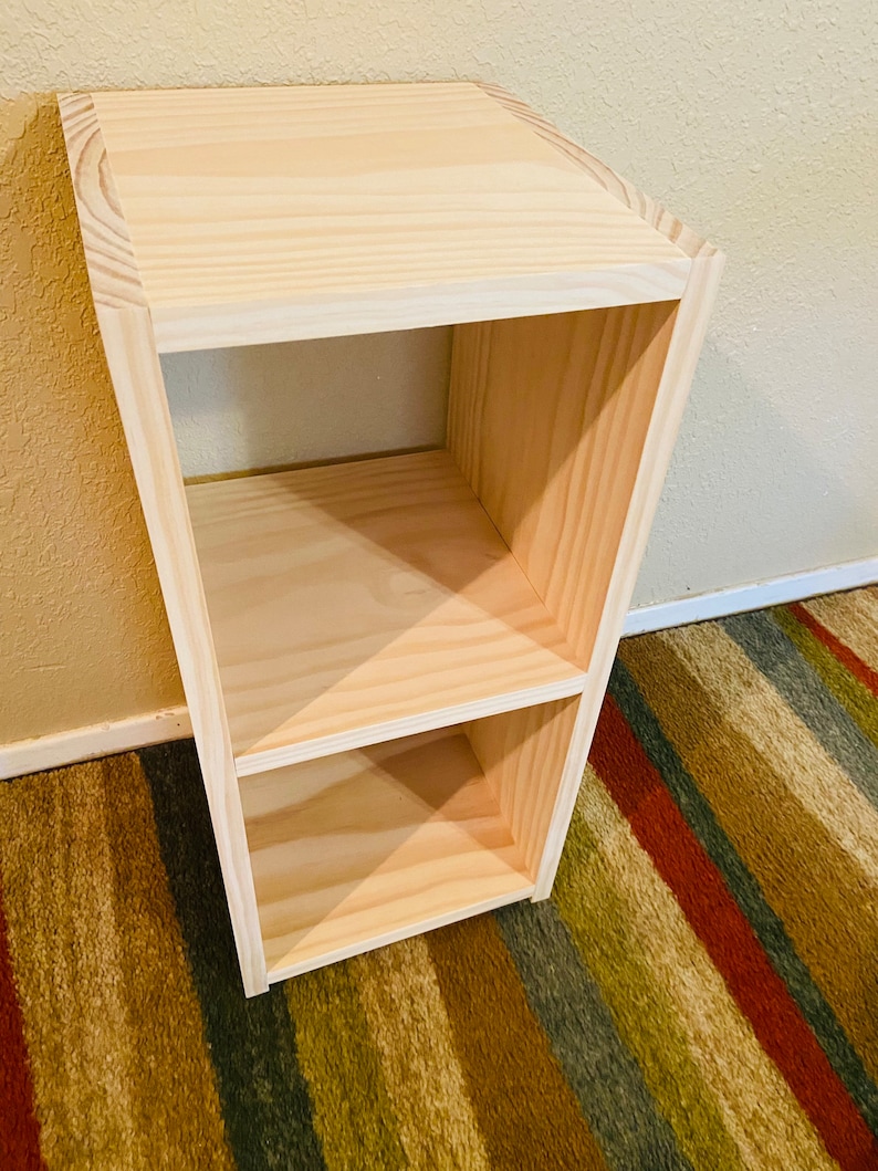 Op de afbeelding: Een eenvoudige, onafgewerkte houten plankeneenheid met twee planken. De plank is gemaakt van natuurlijk hout en heeft een lichtbruine kleur.