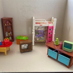 May include: A collection of miniature dollhouse furniture including a brown bookshelf, a white loft bed with a pink ladder, a yellow table with a red tray, a brown television, a green storage bin, and a brown media console with blue baskets.
