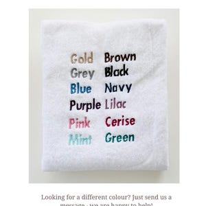 Pu&ograve; includere: Un asciugamano bianco mostra le opzioni di colore per il ricamo: Oro, Marrone, Grigio, Nero, Blu, Blu navy, Viola, Lilla, Rosa, Ciliegia, Menta e Verde. Il testo in basso recita: "Cerchi un colore diverso? Inviaci un messaggio: saremo felici di aiutarti!"