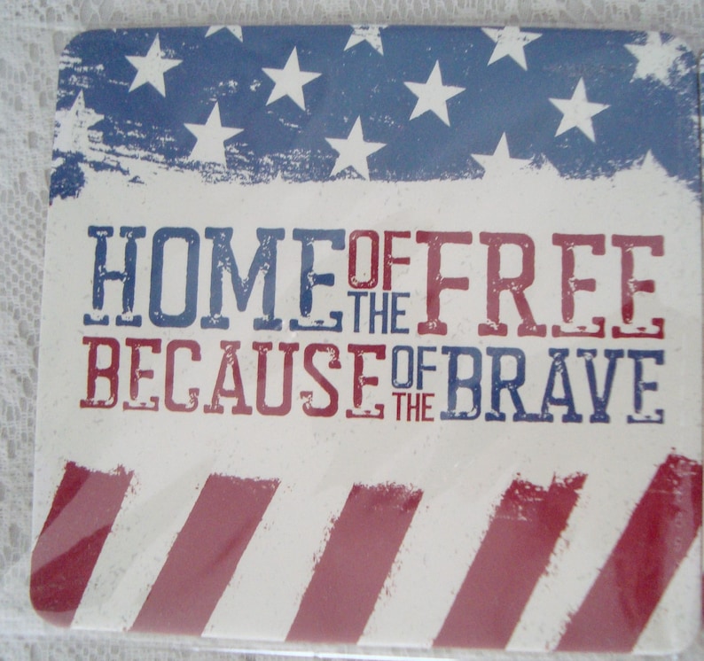 May include: Square coaster with a patriotic design. The top features a blue background with white stars and the text "HOME OF THE FREE BECAUSE OF THE BRAVE" in red and blue. Red and white stripes are at the bottom.