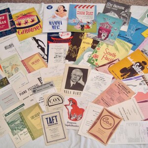 Puede incluir: Una colección de programas y folletos de teatro vintage, con títulos como "Guys and Dolls" y "Carousel". El surtido incluye varios colores y diseños, mostrando los estilos gráficos de la época.