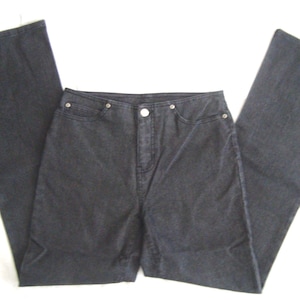May include: A pair of dark charcoal grey denim jeans featuring a high-waisted design, a central button closure, and a wide-leg silhouette. The jeans include two front pockets with silver-toned metal rivets at the corners and a standard fly front.