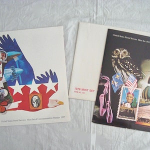Può includere: Una collezione di serie di francobolli commemorativi. Una copertina presenta un design patriottico con un'aquila, stelle e strisce. Un'altra copertina mostra un gufo, scarpette da ballo e francobolli. I set sono del 1977 e 1978.