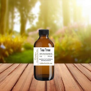 May include: A brown glass bottle of Tea Tree essential oil. The bottle is labeled with the text "Caliber Products for Life" and "Tea Tree 100% Pure Essential Oil 4 oz 118.3 ml". The ingredients are listed as "Tea Tree (Melaleuca alternifolia) essential oil". The website address "CaliberForLife.com" is printed on the label.