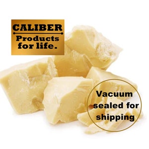 May include: Chunks of pale yellow cocoa butter are displayed against a white background. The image includes text that reads "CALIBER Products for life." and "Vacuum sealed for shipping."