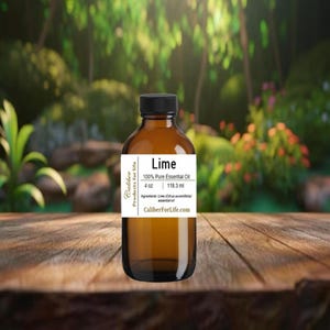 May include: A brown glass bottle with a black cap, labeled "Lime 100% Pure Essential Oil." The label also indicates 4 oz and 118.3 ml. The bottle is on a wooden surface with a blurred green and floral background.