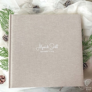Álbum de fotos de lino con inscripción personalizada en blanco.