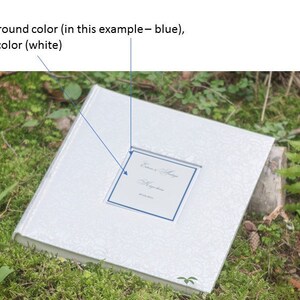 Puede incluir: Un &aacute;lbum de bodas blanco con un borde azul alrededor de una peque&ntilde;a ventana que muestra los nombres "Susan & John" y la fecha "May 20, 2023".