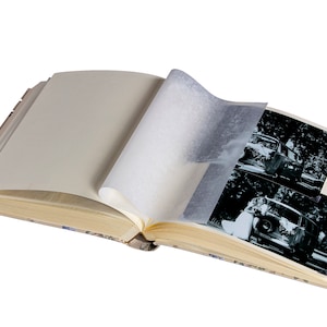 K&ouml;nnte beinhalten: Ein offenes Fotoalbum mit Vintage-Charakter, das Schwarzwei&szlig;fotos eines Paares in einem Auto zeigt. Das Album hat einen cremefarbenen Einband mit einem Blumenmuster.