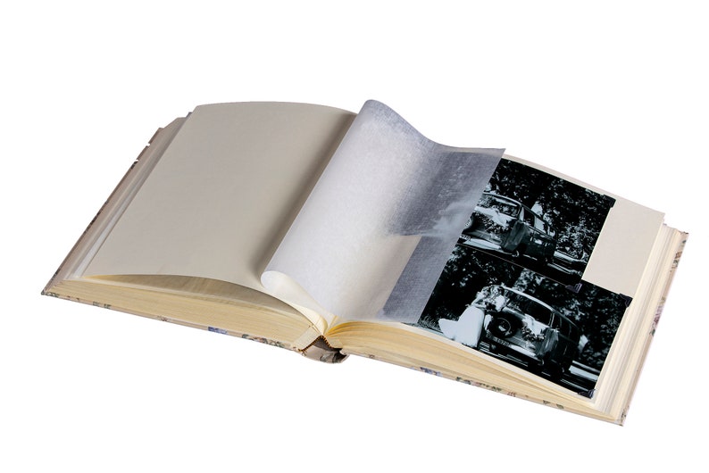 K&ouml;nnte beinhalten: Ein offenes Fotoalbum mit Vintage-Charakter, das Schwarzwei&szlig;fotos eines Paares in einem Auto zeigt. Das Album hat einen cremefarbenen Einband mit einem Blumenmuster.