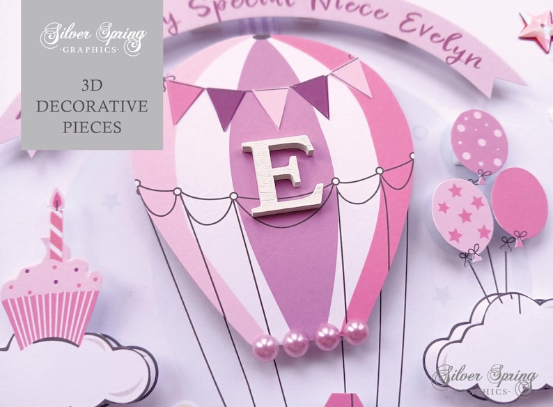 May include: A pink and white hot air balloon with a wooden letter E in the center. The balloon is decorated with pink and white stripes and a string of pink flags. The balloon is surrounded by pink and white clouds and stars. The text "My Special Niece Evelyn" is written on a banner above the balloon.