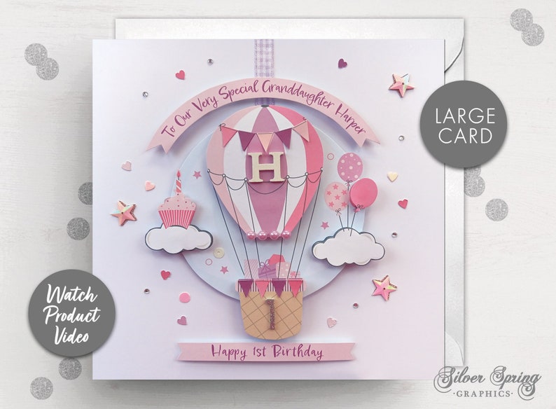 May include: A pink and white hot air balloon with a pink cupcake and stars on a white card. The card says "To Our Very Special Granddaughter Harper" and "Happy 1st Birthday".