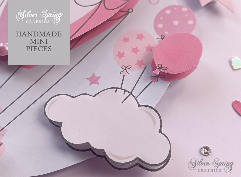 May include: Pink and white paper craft with a cloud, stars, and balloons. The balloons have a polka dot pattern, a star pattern, and are solid pink. The text "Handmade Mini Pieces" is on the craft.