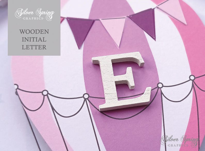 May include: White wooden letter E on a pink and white hot air balloon background with purple and pink pennant flags.  Wooden Initial Letter.