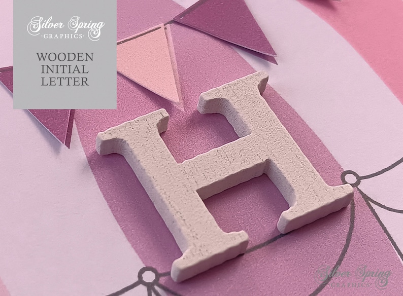 May include: White wooden letter H on a pink and white background with a banner design. The letter is a craft supply for scrapbooking, card making, and other DIY projects.