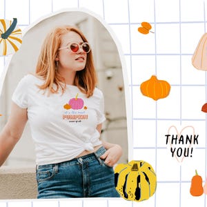 May include: A white t-shirt with a pink pumpkin graphic and the text "It's the most PUMPKIN time of all". The model is wearing the shirt with blue jeans and sunglasses. The background is a grid pattern with fall-themed illustrations.