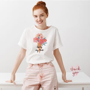 May include: White t-shirt with a floral ice cream cone graphic and the text "doing my best".