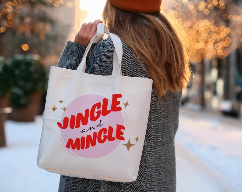 May include: A white tote bag with the words "Jingle and Mingle" in red script and a pink circle. Gold stars are scattered around the text. The bag is carried by a person wearing a gray coat and a brown hat.