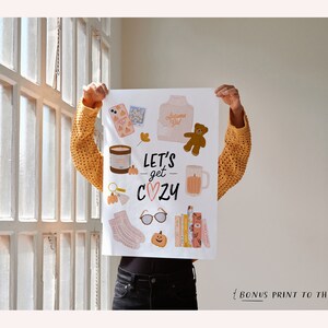 May include: A white printable poster with illustrations of cozy fall items, including a mug, a teddy bear, a pumpkin, a book, and a pair of glasses. The text on the poster reads "Let's get cozy".