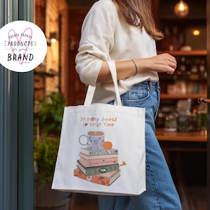 K&ouml;nnte beinhalten: Wei&szlig;e Einkaufstasche mit dem Text "So many books, so little time" und einer Grafik einer Tasse Kaffee und einem Stapel B&uuml;cher.