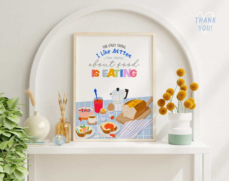 May include: A colorful kitchen print with the text "The only thing I like better than taking about food is eating". The print features a breakfast scene with a loaf of bread, a coffee pot, a bowl of fruit, and a plate of eggs.