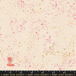 Peut inclure: Tissu crème avec un motif tacheté de points roses et dorés. Le tissu a une texture subtile et un design artistique et ludique. Le bas de l'image porte la mention "RUBY STAR SOCIETY".