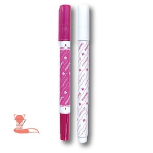 May include: Two marking pens for fabric, one with a magenta barrel and cap, and one with a white barrel and cap. Both pens feature the text Sewline and moda printed in a repeating diagonal pattern along the body, along with small flower icons.