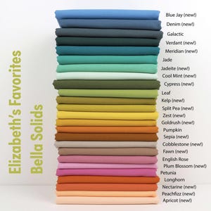 May include: A stack of folded fabric in various colors, including blue, green, yellow, orange, and pink. The text "Elizabeth's Favorites Bella Solids" is on the left. Color names like "Blue Jay," "Denim," and "Pumpkin" are listed on the right.