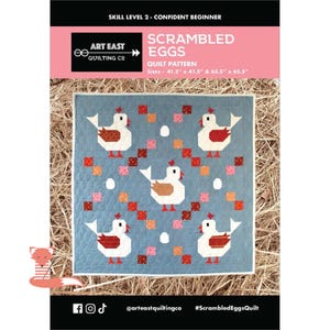 May include: A blue quilt with a chicken pattern, featuring red, white, and brown chickens, along with red, pink, and orange squares. The quilt pattern is called "Scrambled Eggs" and is available in 41.5" x 41.5" and 65.5" x 65.5" sizes.