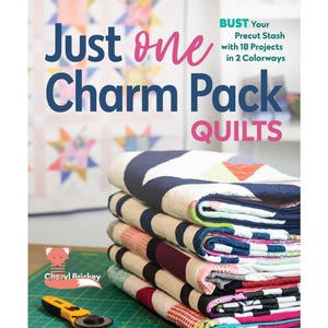 May include: Book cover with the title "Just one Charm Pack Quilts" and a stack of colourful quilts. The book cover also features a fox illustration and the text "BUST Your Precut Stash with 18 Projects in 2 Colorways".