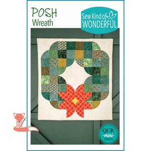 Puede incluir: Un tapiz de tela con un diseño de corona acolchada. La corona está compuesta por cuadrados verdes, amarillos y estampados, con una flor roja y naranja en la parte inferior. El texto "POSH Wreath" y "Sew Kind of WONDERFUL" son visibles.