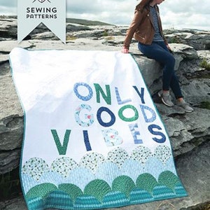 May include: A white quilt with the words "ONLY GOOD VIBES" in blue and green letters. The quilt has a scalloped border and is a letter board quilt pattern. The image also includes the text "PRE CUT FRIENDLY!"