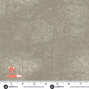 May include: A fabric with a distressed, textured appearance in shades of gray and beige, speckled with white dots. A cartoon fox with a needle and thread is in the lower left corner. The fabric is marked with a ruler.